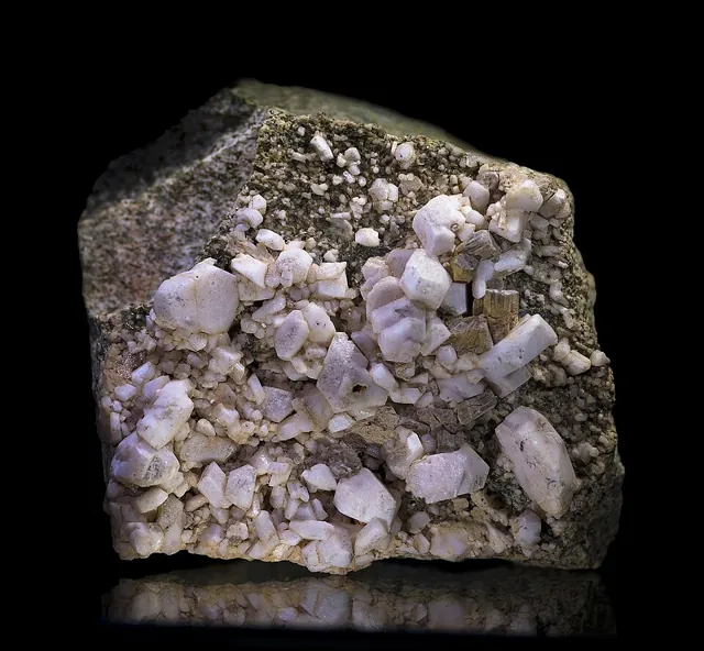 Albite (NaAlSi₃O₈) : minéral de la famille « silicates (tectosilicates) », système triclinique, dureté 6 à 6,5 (Mohs), couleurs : blanc, incolore, gris, bleuté