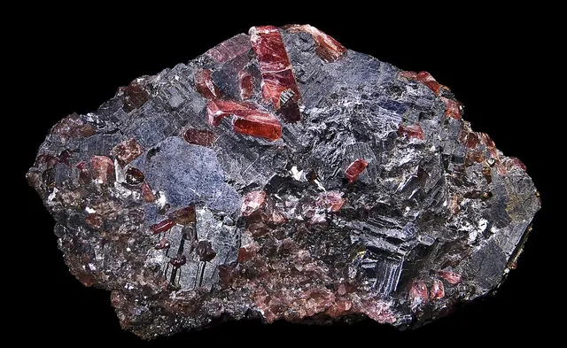 Bustamite ((Mn,Ca)₃Si₃O₉) : minéral de la famille « silicates (inosilicates) », système triclinique, dureté 5,5 à 6,5 (Mohs), couleurs : rose, rose orangé, brun rose