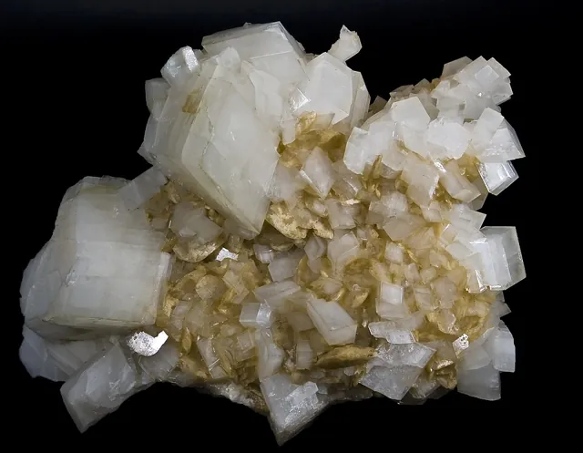 Dolomite (CaMg(CO₃)₂) : minéral de la famille « carbonates », système trigonal, dureté 3,5 à 4 (Mohs), couleurs : blanc, rose, gris, incolore, brunâtre