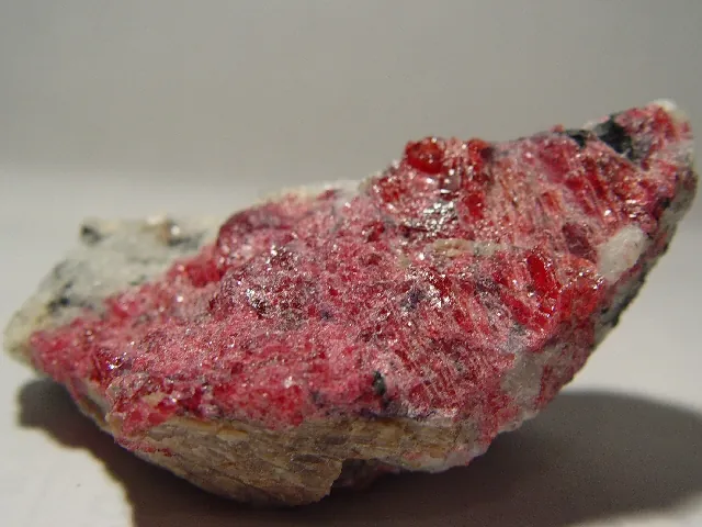 Eudialyte (Na₁₅Ca₆Fe₃Zr₃Si(Si₂₅O₇₃)(O,OH,H₂O)₃(Cl,OH)₂) : minéral de la famille « silicates (cyclosilicates) », système trigonal, dureté 5 à 5,5 (Mohs), couleurs : rouge, rose, brun