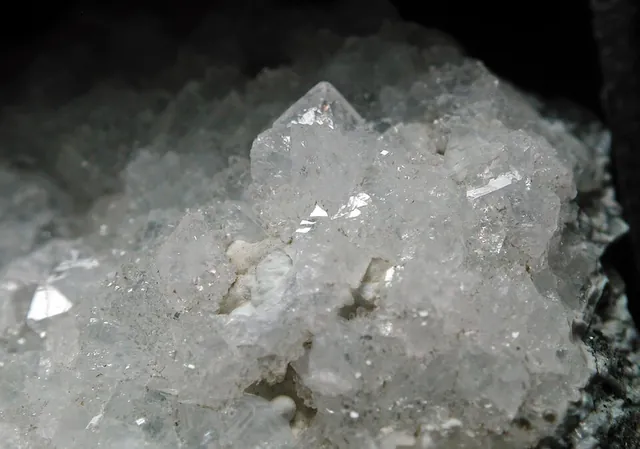 Gismondine (CaAl₂Si₂O₈·4,5H₂O) : minéral de la famille « silicates (tectosilicates) », système monoclinique, dureté 4,5 (Mohs), couleurs : incolore, blanc, gris