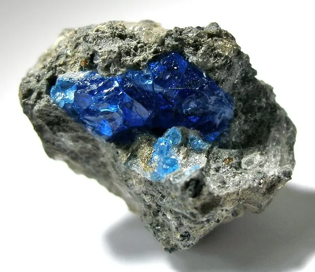 Haüyne (Na₃Ca(Si₃Al₃)O₁₂(SO₄)) : minéral de la famille « silicates (tectosilicates) », système cubique, dureté 5,5 à 6 (Mohs), couleurs : bleu vif, bleu ciel, blanc, gris