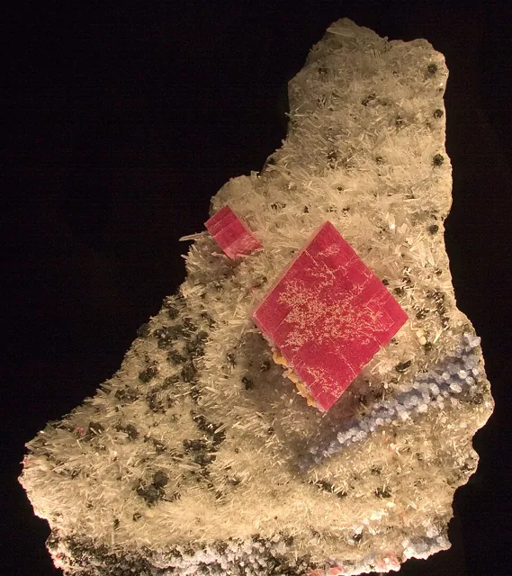 Rhodochrosite (MnCO₃) : minéral de la famille « carbonates », système trigonal, dureté 3,5 à 4 (Mohs), couleurs : rose, rouge framboise, orangé
