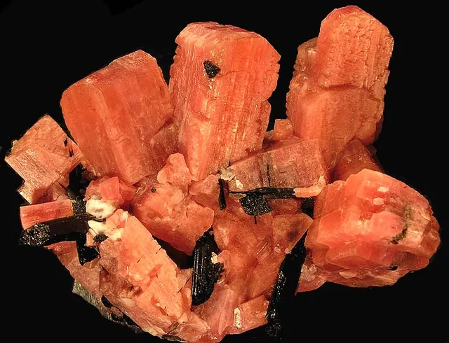 Sérandite (Na(Mn,Ca)₂Si₃O₈(OH)) : minéral de la famille « silicates (inosilicates) », système triclinique, dureté 5 à 5,5 (Mohs), couleurs : rose saumon, rouge, brun rose