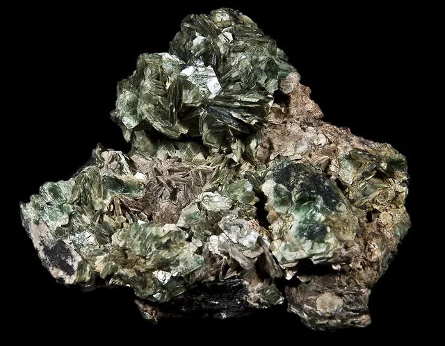 Zinnwaldite (KLiFe²⁺Al(AlSi₃)O₁₀(F,OH)₂) : minéral de la famille « silicates (phyllosilicates) », système monoclinique, dureté 2,5 à 4 (Mohs), couleurs : gris brun, argenté, brun
